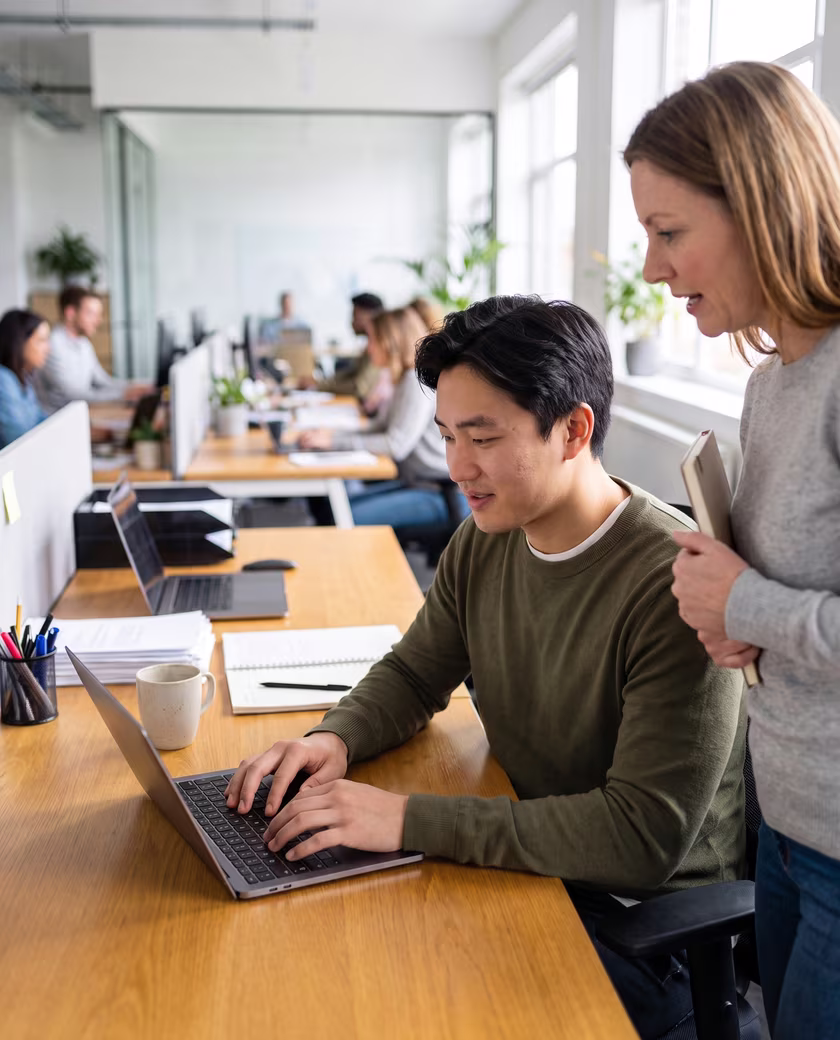 An Amast trainer working alongside a participant at his own desk